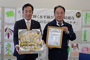 写真：JGAP認証取得した広野町産バナナ「綺麗」を持つ町長