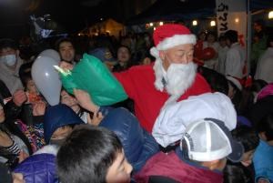 写真：サンタクロースにふんした山田町長が子どもたちにプレゼントを配っている様子