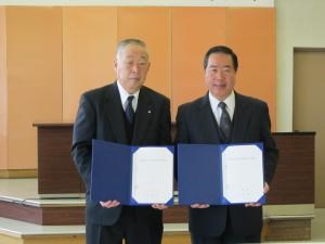 写真：協定書にサインした山田町長（左）、宍戸町長（右）