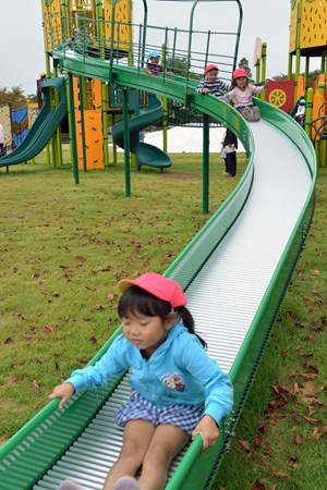 写真：大型複合遊具で園児がすべり台をすべる様子