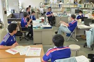写真：町役場の職員がサッカー日本代表ユニフォームを着用して執務している様子