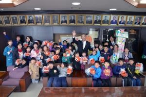 写真：遠藤町長と児童が年賀状を持っている様子