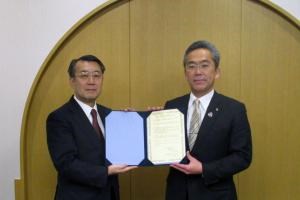 写真：遠藤町長と大和裕幸理事・副学長が協定書を取り交わしている様子