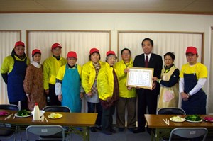 写真：遠藤町長が仮設住宅での支援活動をしていただいた金子英夫さん、令子さんご夫妻に感謝状を贈っている様子
