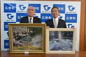 写真：鶴田徳満さんが寄贈の絵画を遠藤町長に手渡している様子
