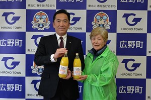 写真：みかんジュースを持つ塩史子二ツ沼直売所組合長と遠藤町長